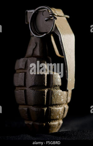 Grenade d'ananas comme utilisé par les forces américaines pendant la Seconde Guerre mondiale, sur un fond noir. Banque D'Images