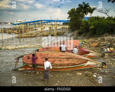 4 novembre 2015 - Dala, Division de Yangon, Myanmar - small wooden ferries sont réparées sur les rives de la rivière Yangon à Dala. Dala est situé sur la rive sud du fleuve Yangon en face du centre-ville de Yangon, Myanmar. De nombreux Birmans vivent dans Dala et les communautés environnantes et aller de l'autre côté de la rivière dans le centre de Yangon pour travailler. Avant la Seconde Guerre mondiale, l'Irrawaddy Flotilla Company avait ses principaux chantiers de Dala. Cette tradition perdure dans les petites entreprises les travaux de réparation sur les centaines de petits bateaux en bois qui servent de ferries de banlieue pour les habitants de Yangon. Les bateaux sont tirés sur le ri Banque D'Images