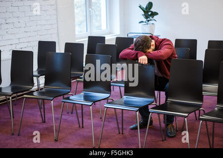 Assez Jeune homme tenant en rappel et gaz dans la salle de conférence Banque D'Images