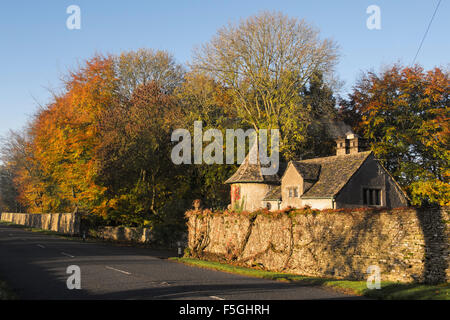 Stowell Park gate house et de hêtres avec feuillage automne dans la campagne des Cotswolds. Le Gloucestershire, Angleterre. Banque D'Images