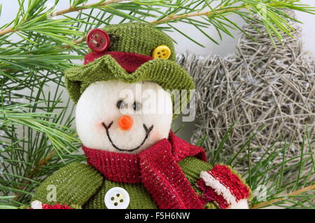 Parmi les branches de sapin bonhomme de neige avec les flocons. L'hiver Banque D'Images