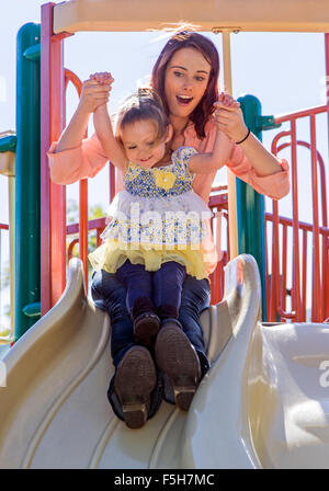 Belle Mère et jeune fille fille jouant à l'extérieur, sur une planche, town park Banque D'Images