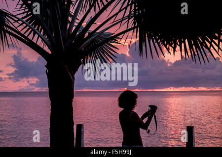 Une femme vérifie une image sur son écran LCD de l'appareil photo tout en prenant des photos au coucher du soleil, à Sainte-Croix, U.S.V.I. Îles Vierges Américaines ILES VIERGES AMÉRICAINES Banque D'Images