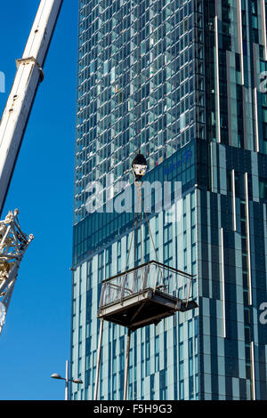 L'article de démantelé étapes être soulevé par une grue avec la Beetham Tower derrière. Manchester, Angleterre, RU Banque D'Images