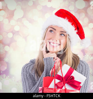 Image composite de blonde de fête avec un cadeau et le sac Banque D'Images