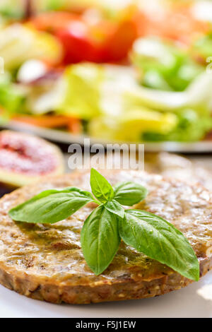 Libre d'une plaque dans un Veggie burger et une assiette avec la salade dans l'arrière-plan Banque D'Images