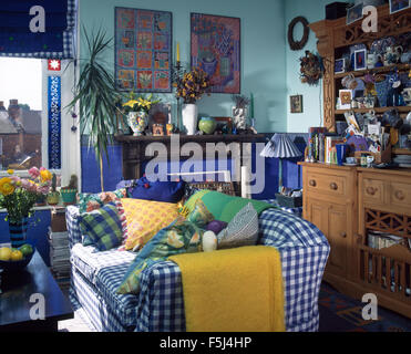 Vérifier la couverture bleu et jaune en vrac jeter sur un canapé dans un salon de style économique 90 Banque D'Images