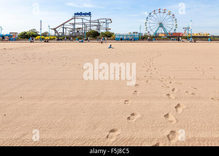 Empreintes sur la plage menant au parc d'attractions Pleasure Beach à Skegness, dans le Lincolnshire, Angleterre, RU Banque D'Images