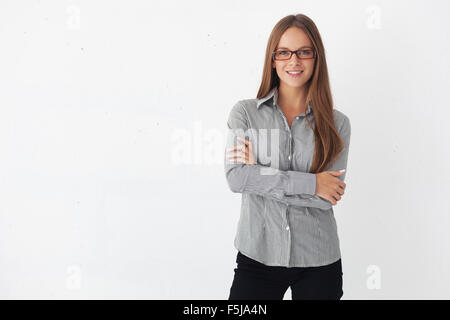 Portrait of young beautiful business woman standing contre mur blanc. Banque D'Images