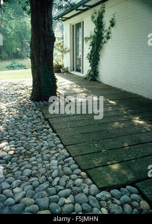 Decking en bois et de galets, à côté d'asphaltage du chemin house Banque D'Images