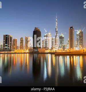 Skyline de tours reflété dans le ruisseau au crépuscule dans la baie d'affaires à Dubaï Émirats Arabes Unis Banque D'Images