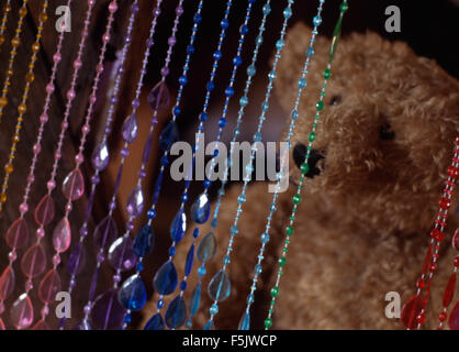 Close-up d'un rideau de perles et d'un ours en peluche Banque D'Images