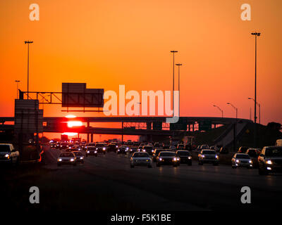 C'est une longue journée de la lutte contre le trafic à rentrer à la maison après le travail. Pare-chocs à pare-chocs de la circulation sur une autoroute importante alors que le soleil se couche à l'Ouest. Banque D'Images