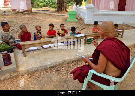 Le moine bouddhiste à l'extérieur, dans les leçons d'enseignement les élèves les motifs de stupas et temples près de Mandalay Myanmar (Birmanie) Banque D'Images