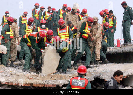 Les responsables de l'armée pakistanaise et sauve deux occupé dans l'opération de recherche de sauvetage pour les victimes dans les décombres d'une usine s'est effondrée sur le site de l'accident après l'effondrement des bâtiments de l'usine à Sundar Industrial Estate près de Lahore le Jeudi, Novembre 05, 2015. Au moins 23 morts, des dizaines toujours prisonniers après l'effondrement de l' usine à Sundar Industrial Estate, le mercredi soir. Quatre étages d'une usine de production de sacs en plastique s'est effondré, le piégeage des douzaines de travailleurs sous les décombres à l'Sundar Industrial Estate près de Lahore. Banque D'Images