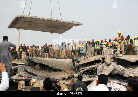 Les responsables de l'armée pakistanaise et sauve deux occupé dans l'opération de recherche de sauvetage pour les victimes dans les décombres d'une usine s'est effondrée sur le site de l'accident après l'effondrement des bâtiments de l'usine à Sundar Industrial Estate près de Lahore le Jeudi, Novembre 05, 2015. Au moins 23 morts, des dizaines toujours prisonniers après l'effondrement de l' usine à Sundar Industrial Estate, le mercredi soir. Quatre étages d'une usine de production de sacs en plastique s'est effondré, le piégeage des douzaines de travailleurs sous les décombres à l'Sundar Industrial Estate près de Lahore. Banque D'Images