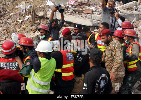 Les responsables de l'armée pakistanaise et sauve deux occupé dans l'opération de recherche de sauvetage pour les victimes dans les décombres d'une usine s'est effondrée sur le site de l'accident après l'effondrement des bâtiments de l'usine à Sundar Industrial Estate près de Lahore le Jeudi, Novembre 05, 2015. Au moins 23 morts, des dizaines toujours prisonniers après l'effondrement de l' usine à Sundar Industrial Estate, le mercredi soir. Quatre étages d'une usine de production de sacs en plastique s'est effondré, le piégeage des douzaines de travailleurs sous les décombres à l'Sundar Industrial Estate près de Lahore. Banque D'Images