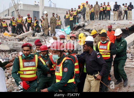 Les responsables de l'armée pakistanaise et sauve deux occupé dans l'opération de recherche de sauvetage pour les victimes dans les décombres d'une usine s'est effondrée sur le site de l'accident après l'effondrement des bâtiments de l'usine à Sundar Industrial Estate près de Lahore le Jeudi, Novembre 05, 2015. Au moins 23 morts, des dizaines toujours prisonniers après l'effondrement de l' usine à Sundar Industrial Estate, le mercredi soir. Quatre étages d'une usine de production de sacs en plastique s'est effondré, le piégeage des douzaines de travailleurs sous les décombres à l'Sundar Industrial Estate près de Lahore. Banque D'Images