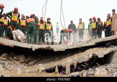 Les responsables de l'armée pakistanaise et sauve deux occupé dans l'opération de recherche de sauvetage pour les victimes dans les décombres d'une usine s'est effondrée sur le site de l'accident après l'effondrement des bâtiments de l'usine à Sundar Industrial Estate près de Lahore le Jeudi, Novembre 05, 2015. Au moins 23 morts, des dizaines toujours prisonniers après l'effondrement de l' usine à Sundar Industrial Estate, le mercredi soir. Quatre étages d'une usine de production de sacs en plastique s'est effondré, le piégeage des douzaines de travailleurs sous les décombres à l'Sundar Industrial Estate près de Lahore. Banque D'Images