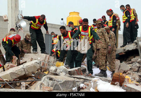 Les responsables de l'armée pakistanaise et sauve deux occupé dans l'opération de recherche de sauvetage pour les victimes dans les décombres d'une usine s'est effondrée sur le site de l'accident après l'effondrement des bâtiments de l'usine à Sundar Industrial Estate près de Lahore le Jeudi, Novembre 05, 2015. Au moins 23 morts, des dizaines toujours prisonniers après l'effondrement de l' usine à Sundar Industrial Estate, le mercredi soir. Quatre étages d'une usine de production de sacs en plastique s'est effondré, le piégeage des douzaines de travailleurs sous les décombres à l'Sundar Industrial Estate près de Lahore. Banque D'Images