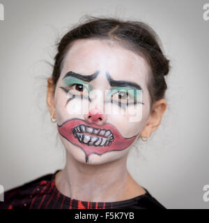 Portrait d'une jeune britannique de 10 ans / Thai girl habillés pour halloween avec clown face paint Banque D'Images