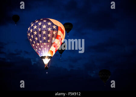 Allumé Stars and Stripes hot air balloon flying Dawn Patrol, Albuquerque International Balloon Fiesta, Nouveau Mexique USA Banque D'Images