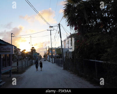 Caye Caulker, Belize. 18 avr, 2012. Un couple marche les rues sablonneuses au coucher du soleil sur cette petite île. Caye Caulker est une petite île de corail calcaire au large du Belize, dans la mer des Caraïbes qui est à environ 5 miles de long. © Julie Rogers/ZUMAPRESS.com/Alamy Live News Banque D'Images