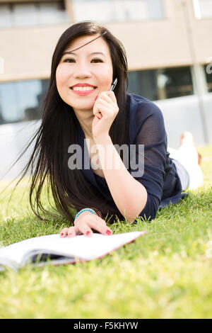 Étudiant japonais allongés sur l'herbe Banque D'Images