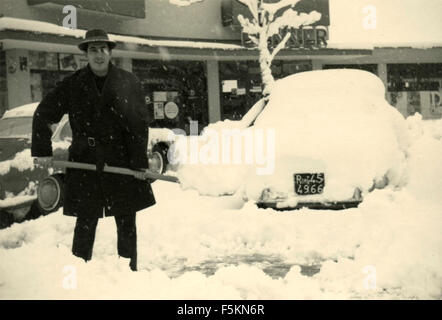 Un homme de pelleter de la neige après la célèbre chute de neige de 1956, Rome, Italie Banque D'Images