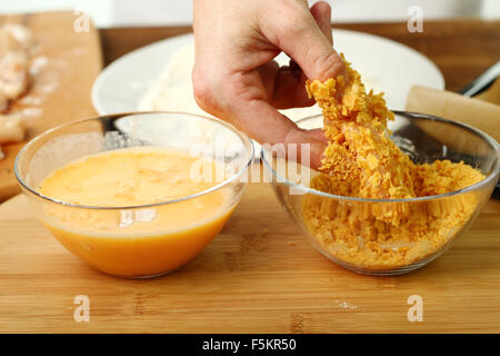 Panés fraîchement dans les flocons de maïs filet de poulet. Faire cuite au four miettes de flocons de maïs nuggets de poulet. Série. Banque D'Images