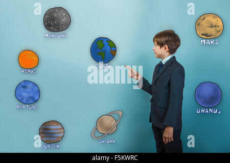 Teen boy businessman en costume indique main sur les planètes de Banque D'Images