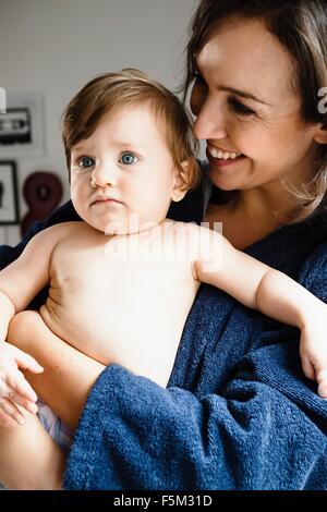 Mother holding baby fils, looking away Banque D'Images