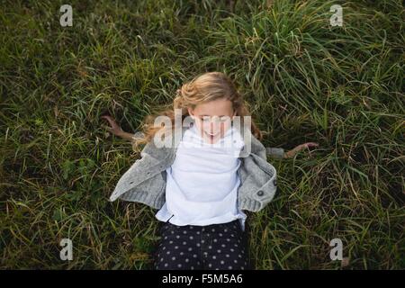 Jeune fille jouant sur l'herbe, overhead view Banque D'Images