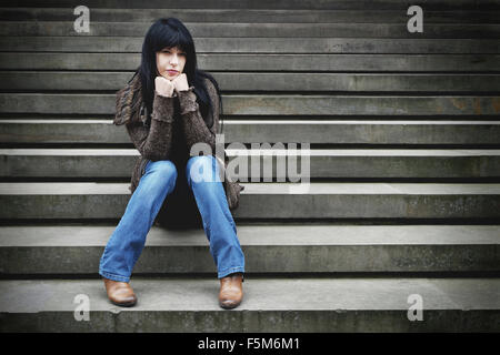 Lonely Woman sitting on steps Banque D'Images