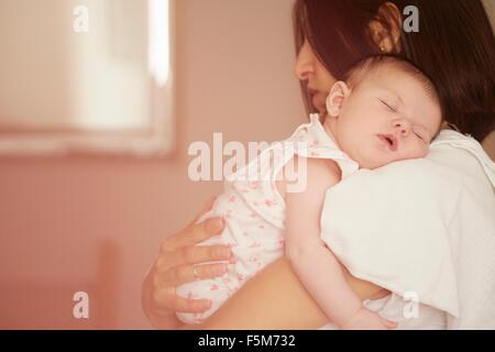 Mère portant bébé endormi Banque D'Images