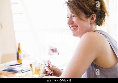 Happy young woman playing card game Banque D'Images