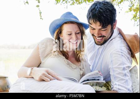 Couple romantique guide de lecture au Safari Lodge, Kafue National Park, Zambie Banque D'Images