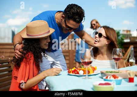 Homme et femme friends chatting at rooftop barbecue Banque D'Images