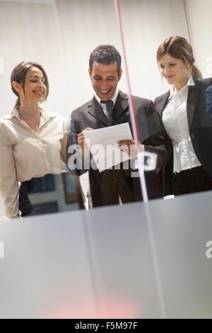 Trois de mes collègues à la recherche à travers des documents dans Office Banque D'Images