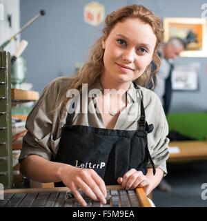 Portrait de jeune femme avec bac en atelier d'impression typographique Banque D'Images