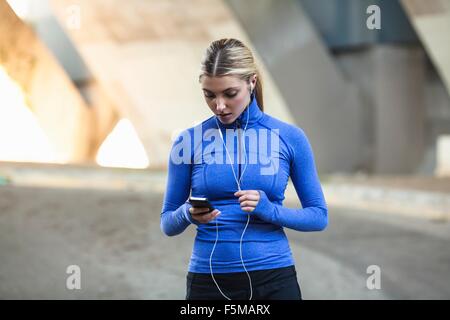 Jogger sélection de musique sur smartphone Banque D'Images