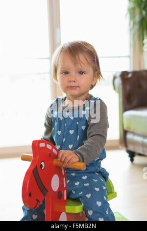 Portrait of female toddler playing sur cheval à bascule Banque D'Images