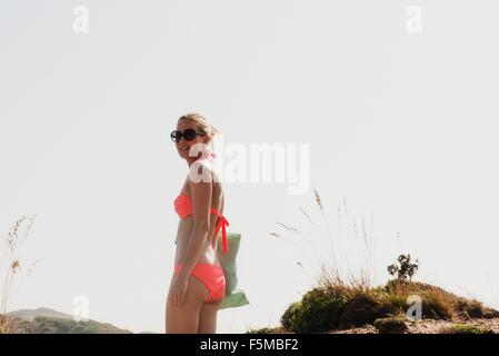 Portrait of woman wearing bikini dans des dunes, Minorque, Espagne Banque D'Images