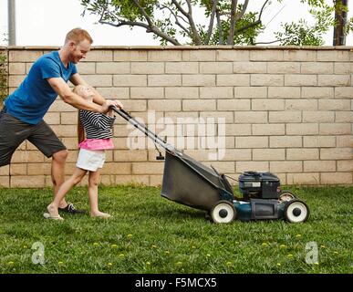 Père et fille la pelouse à l'arrière-cour Banque D'Images