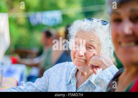 Senior woman daydreaming tomate au festival de l'alimentation Banque D'Images