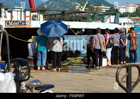 Foule de femmes chinoises en attente pour les captures à la criée sur la jetée de Cheung Chau Island, Hong Kong. Banque D'Images