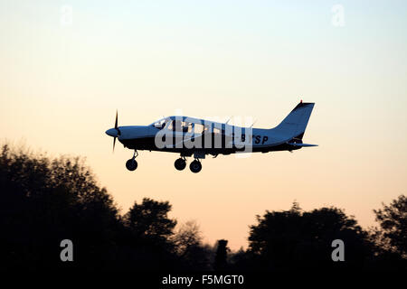 Piper PA-28 Cherokee Archer à l'atterrissage à l'Aérodrome de crépuscule à Wellesbourne, Royaume-Uni (G-BYSP) Banque D'Images