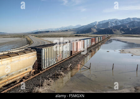 Wagons de chemin de fer en Utah, USA à côté d'un lac de sel inondée Banque D'Images