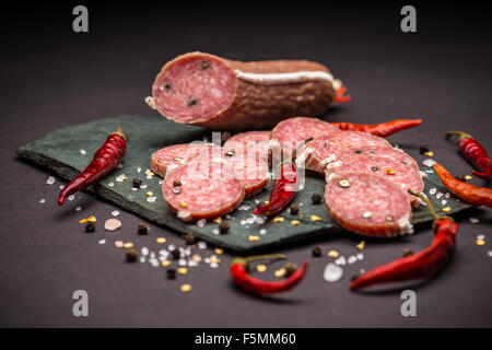 Salami français sur fond d'ardoise noire Banque D'Images