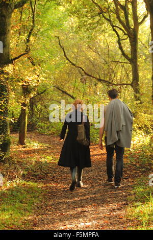 Un homme et une femme marche à travers la forêt dans Stanmore Country Park, près de Wood Lane, Stanmore, Londres, Angleterre, Royaume-Uni - Octobre Banque D'Images